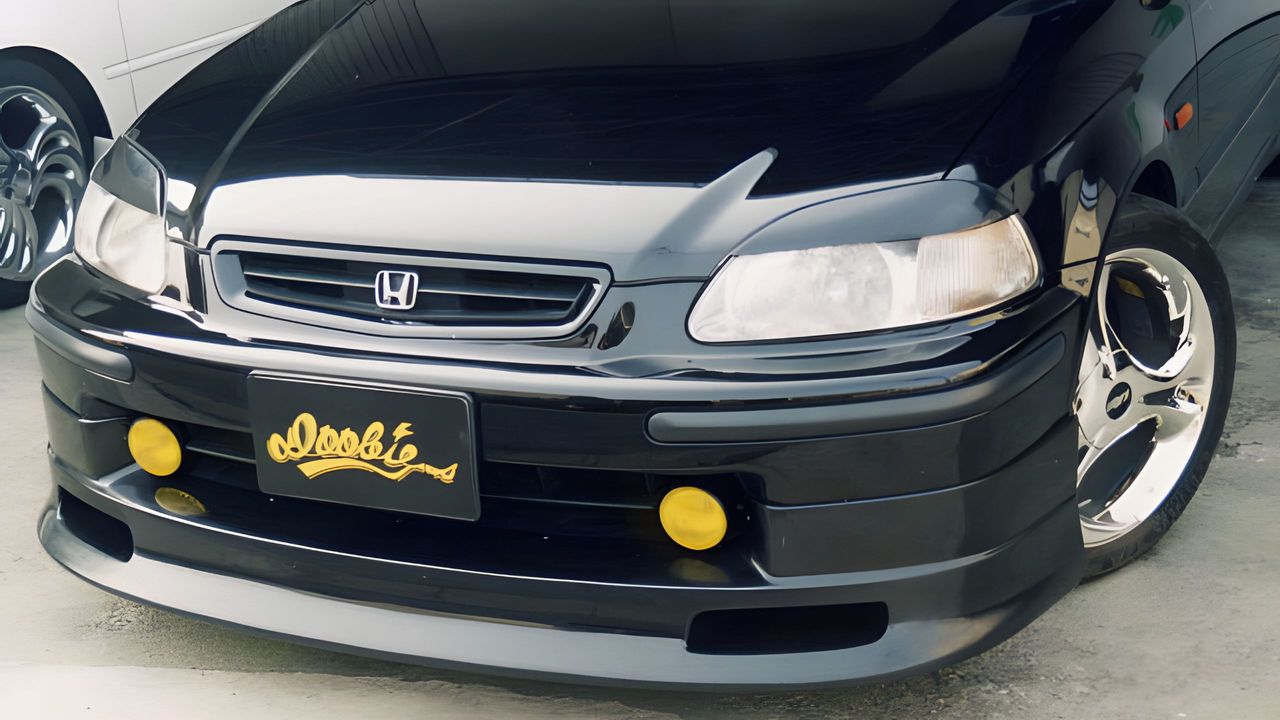 The front end of an EK Civic fitted with a DOOBIE front lip and yellow fog lights