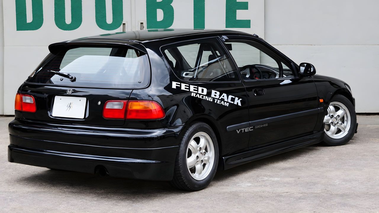 An EG6 Civic at the DOOBIE workshop, the company name painted in green on the wall behind